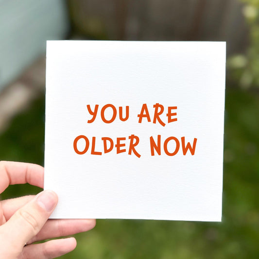 Simple minimalist card with bold orange text reading ‘You are older now’.