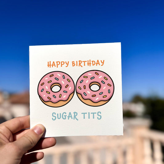 Happy Birthday Sugar Tits Card card being held outdoors, showing front design clearly.