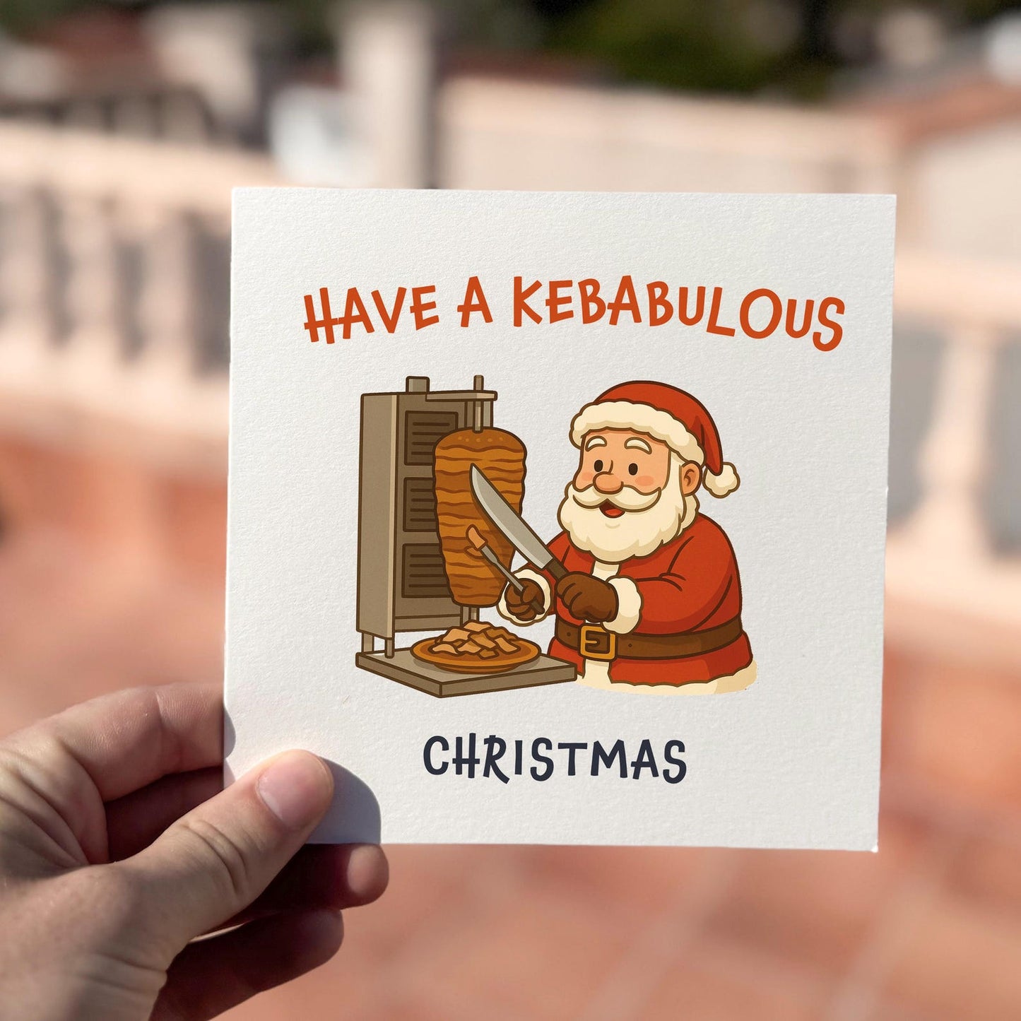 Funny Christmas card featuring Santa slicing doner meat with the text ‘Have A Kebabulous Christmas’.