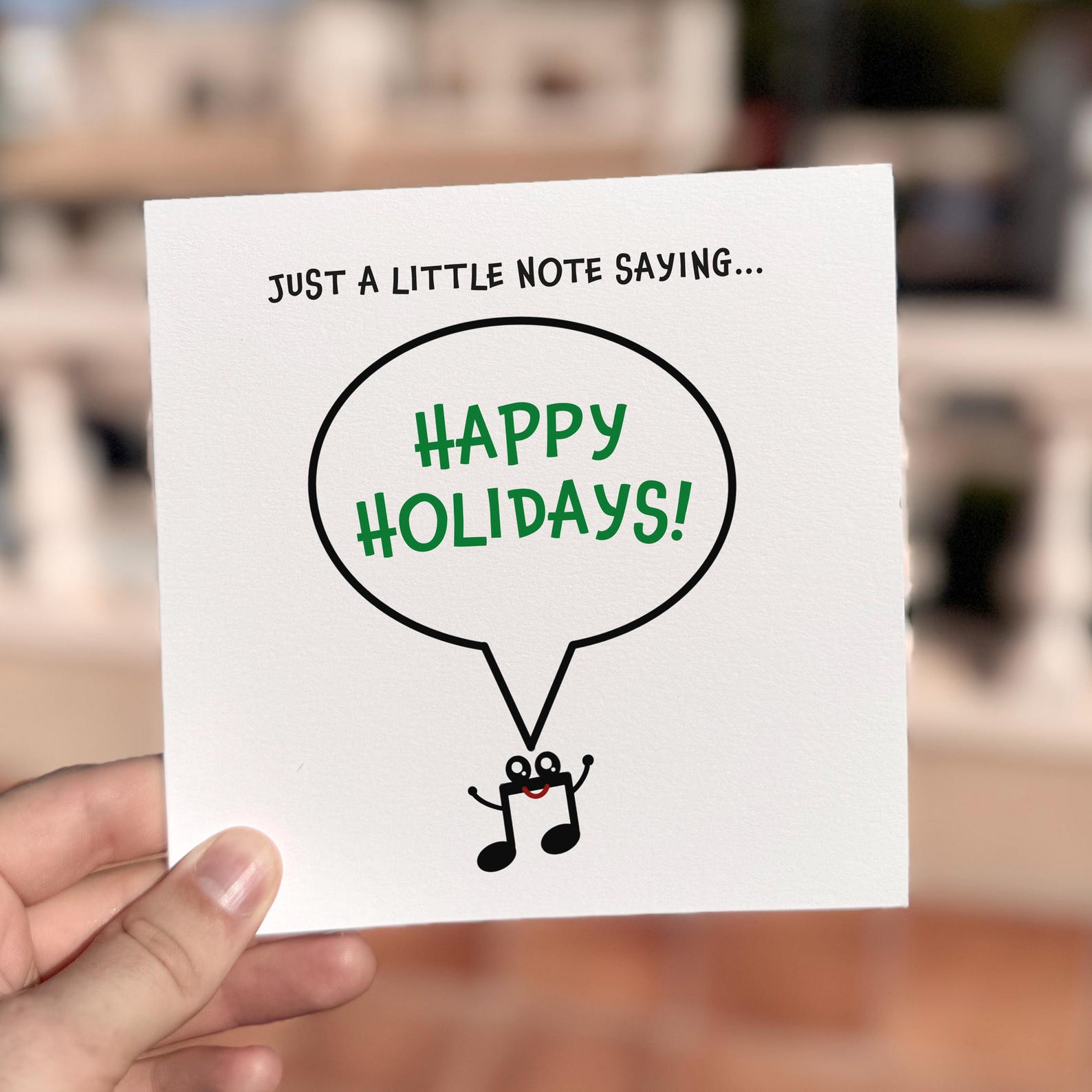 Festive card featuring a smiling musical note character saying ‘Happy Holidays’.