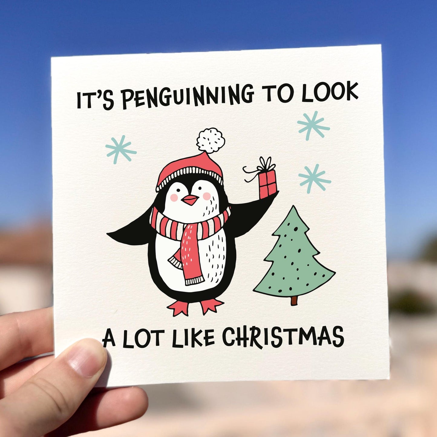 Funny penguin Christmas card with the phrase ‘It’s Penguinning To Look A Lot Like Christmas’.