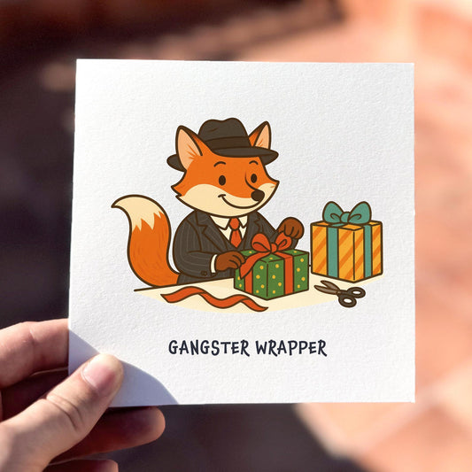 Funny Christmas card featuring a fox in a suit wrapping presents with the text ‘Gangster Wrapper’.