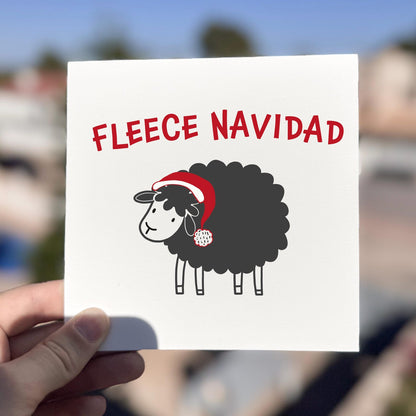 Funny Christmas card featuring a sheep in a Santa hat with the text ‘Fleece Navidad’.