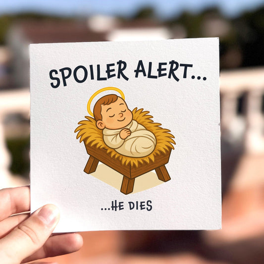 Funny Christmas card featuring baby Jesus in a manger with the text ‘Spoiler Alert… He Dies’.