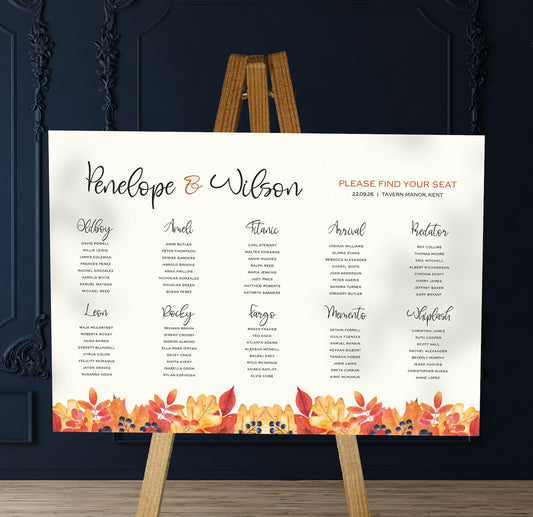 orange and red autumn leaves wedding Table Plan on a brown easel in a stylish room in a wedding venue